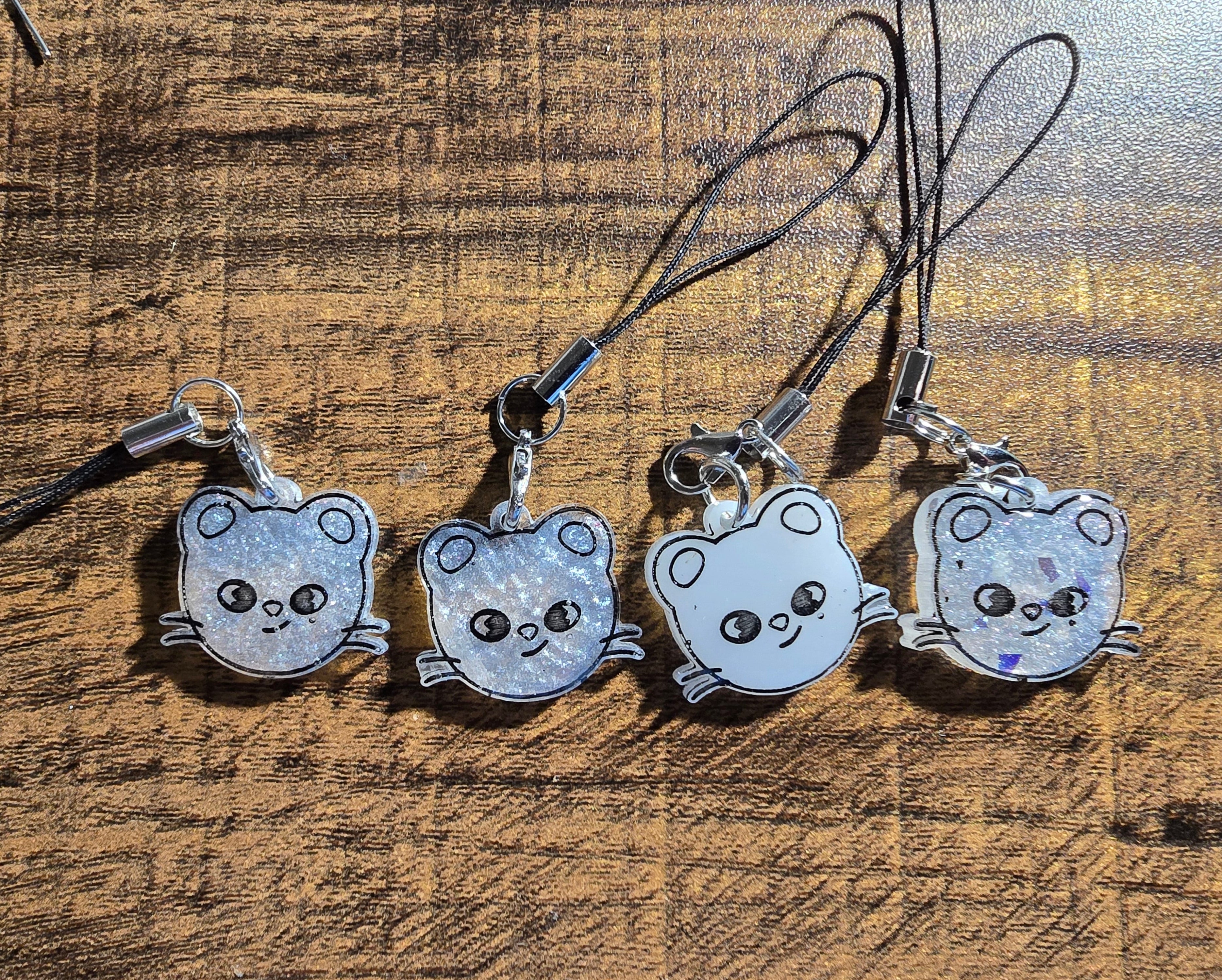 Four jiniret-shaped phone charms on a wooden surface